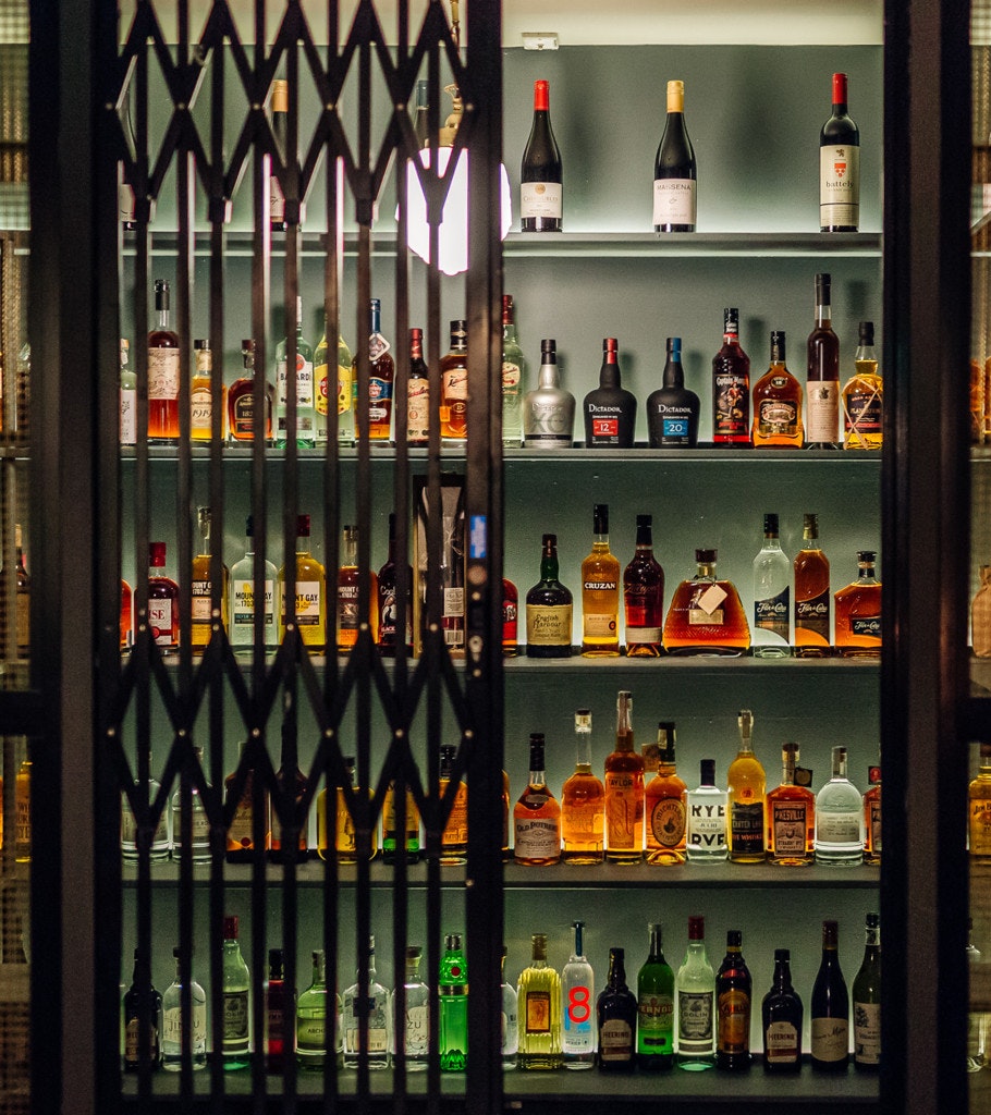 A drinks cabinet with colourful liquours and spirits.